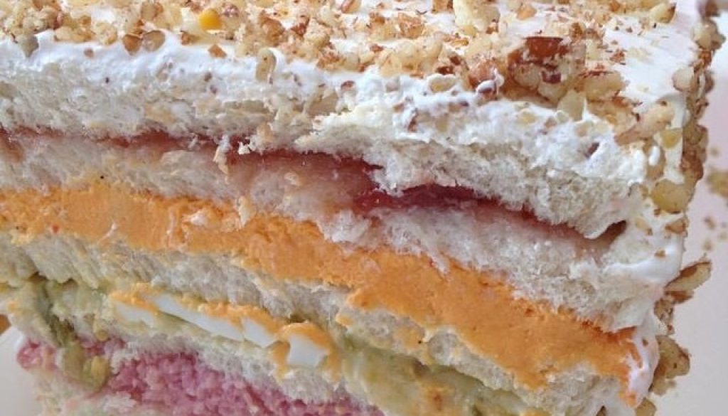 Close look at layers of a Sandwichon topped with nuts and cherries